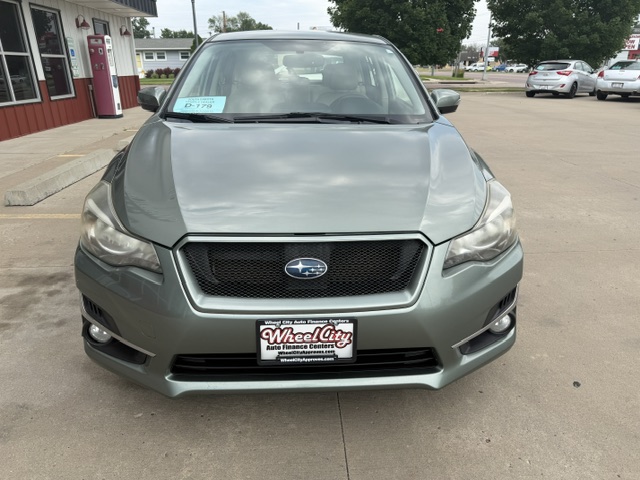 Front view of a gray Subaru SUV at a dealership, Wheel City license plate frame visible on the bumper.