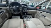 Front-view of a beige Subaru interior from the driver’s seat, showing steering wheel, center console, and gear shifter.