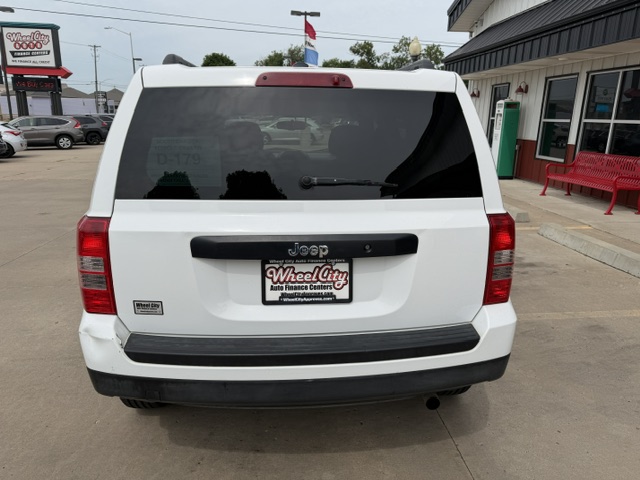 Rear view of a white Jeep SUV in a dealership lot, license plate frame reads Wheel City Auto Finance Centers.