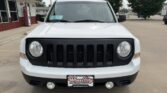Front view of a white SUV with a black seven-slot grille and round headlights, parked at Wheel City Auto Finance Centers.