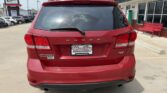 Red Dodge Journey SUV seen from the back in a car dealership lot, with Wheel City Auto Finance Centers license plate frame.