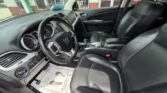 Interior of a car with black leather seats, steering wheel, and center console visible from the driver's side bay window area.