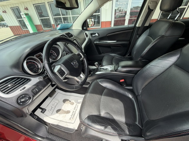 Interior of a car with black leather seats, steering wheel, and center console visible from the driver's side bay window area.