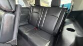 Rear interior of a car with black leather back seats and three headrests.