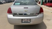 Rear view of a silver Chevrolet Impala LT at a car dealership, windshield tag D-179, with a WheelCity Auto Finance Centers license plate frame.