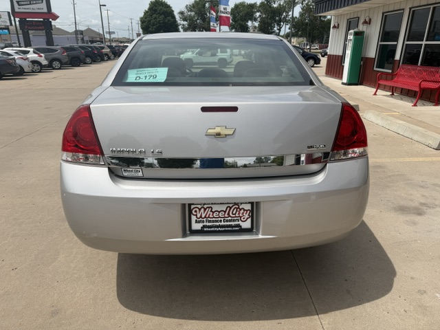 Rear view of a silver Chevrolet Impala LT at a car dealership, windshield tag D-179, with a WheelCity Auto Finance Centers license plate frame.