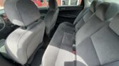 Interior of a sedan showing gray cloth front and rear seats with headrests and visible seat belts in a clean, roomy cabin
