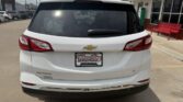 Rear view of a white Chevy SUV in a parking lot, displaying dealership plate frame 'Wheel City Auto Finance Centers'.