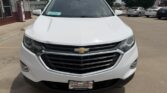 Front view of a white Chevrolet SUV in a dealership lot, showing the prominent grille and Chevrolet bow-tie badge with a dealer plate on the bumper.