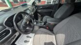Front interior of a Chevy SUV with steering wheel, center console, gear shifter, and cloth front seats.