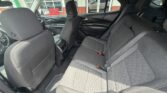 Interior of a mid-size SUV showing the back seats with gray fabric upholstery and seat belts fastened on the right seat edge.