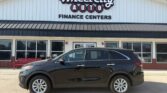 Black SUV parked in front of the Wheel City Auto Finance Centers dealership storefront.
