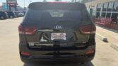 Rear view of a black Kia Sorento SUV parked at a dealership lot, with WheelCity Auto Finance Centers on the license plate frame.