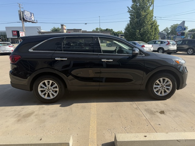 Black mid-size SUV parked in a parking lot, side view with tinted windows and silver door handles.