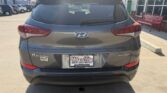 Rear view of a gray Hyundai Tucson with Sport 2.0 badge, parked in a dealership lot; license plate reads 'Wheel City' with a dealership frame.