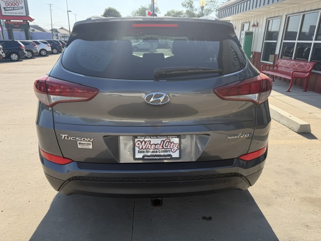 Rear view of a gray Hyundai Tucson with Sport 2.0 badge, parked in a dealership lot; license plate reads 'Wheel City' with a dealership frame.