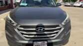 Front view of a gray Hyundai SUV parked in a dealership lot; Wheel City license plate frame visible.