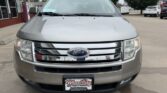 Front view of a silver Ford SUV in a dealership lot, showing chrome grille and license plate frame reading Wheel City Auto Finance Centers
