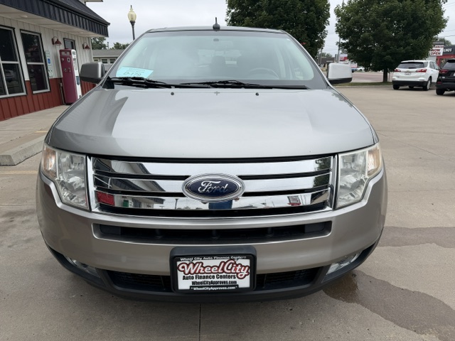 Front view of a silver Ford SUV in a dealership lot, showing chrome grille and license plate frame reading Wheel City Auto Finance Centers
