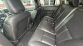 Interior of a car showing the rear seats in black leather with headrests and door panels visible.
