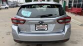 Rear view of a silver Subaru Outback in a dealership lot, with a Wheel City Auto Finance Centers plate frame and a blue D-179 sticker.