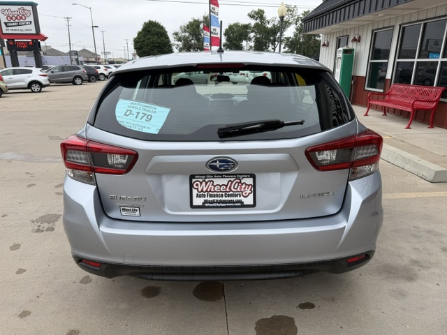 Rear view of a silver Subaru Outback in a dealership lot, with a Wheel City Auto Finance Centers plate frame and a blue D-179 sticker.