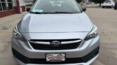 Front view of a silver Subaru sedan in a dealership lot, Wheel City license plate frame visible on the bumper.