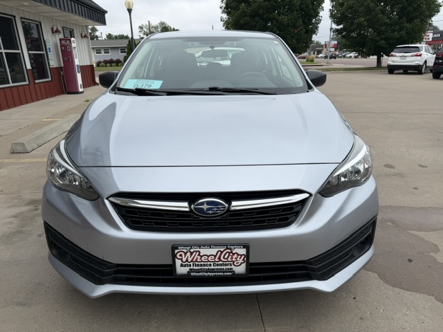 Front view of a silver Subaru sedan in a dealership lot, Wheel City license plate frame visible on the bumper.