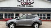 Gray SUV parked in front of Wheel City Auto Finance Centers storefront with large windows and sign above