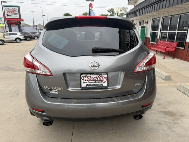 Gray Nissan Murano SUV seen from the rear at a dealership lot; Wheel City license plate frame, AWD badge, visible taillights and rear windshield wiper.