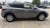 Side view of a gray mid-size SUV with tinted windows and alloy wheels parked in a dealership lot.