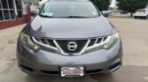 Gray Nissan SUV facing camera in a dealership lot, front view with Wheel City license plate frame.