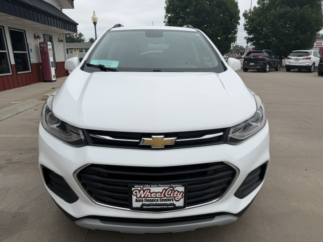 Front view of a white Chevrolet SUV parked in a dealership lot, with the Chevrolet emblem on the grille and a Wheel City Auto Finance Centers license plate frame.