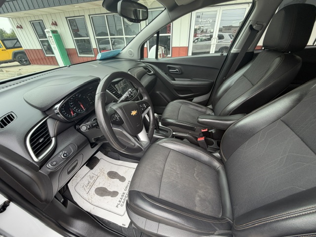 Front interior of a black Chevrolet SUV, showing the driver’s seat, steering wheel, dashboard, and center console.