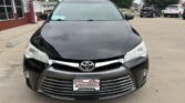 Front view of a black Toyota sedan in a dealership lot, with Wheel City license plate frame on the front bumper.