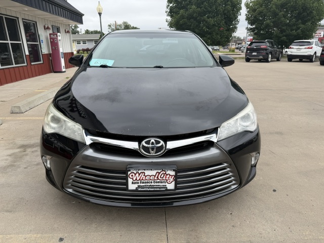 Front view of a black Toyota sedan in a dealership lot, with Wheel City license plate frame on the front bumper.