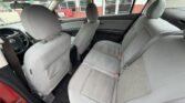 Gray fabric sedan interior with front and back seats visible, door open to show spacious cabin and headrests
