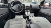 Interior view of a Nissan car from the back seats, showing the steering wheel, dashboard, center console, and front seats.