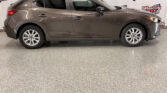 Side profile of a gray crossover SUV parked indoors with Wheel City Auto branding in the background.