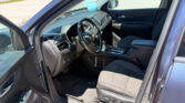 Interior of a Chevrolet SUV showing the steering wheel, center console, and a blue sticky note on the dashboard in front of the passenger seat.