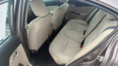 Back seat of a beige fabric interior car with front seats visible and rear door open