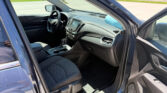 Open front driver-side door view of a Chevrolet car interior, showing steering wheel, center console, and dashboard.