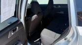 Interior view of a gray SUV with front and back seats visible; a paper is taped to the driver’s-side window