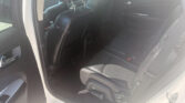 Backseat area of a car with black leather seats and red stitching, visible headrests, and an open rear door.
