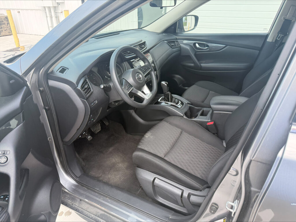 Interior view of a modern car: driver and passenger seats, dashboard, and center console.