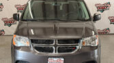 Front view of a gray Dodge SUV indoors, with a Wheel City Auto Finance Centers backdrop visible behind the windshield