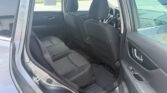 Rear interior of a dark fabric SUV seen from the open rear passenger door, with front seats and headrests visible.