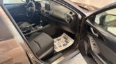 Interior of a car with the driver’s door open, showing the steering wheel, center touchscreen, gear shifter, and front seats.
