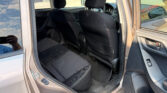 Interior of a black-fabric car showing the rear seat and front seats with headrests, plus the dashboard and steering wheel visible.