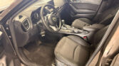 Interior of a Mazda with the driver's seat, steering wheel, and center console visible from the open front door.
